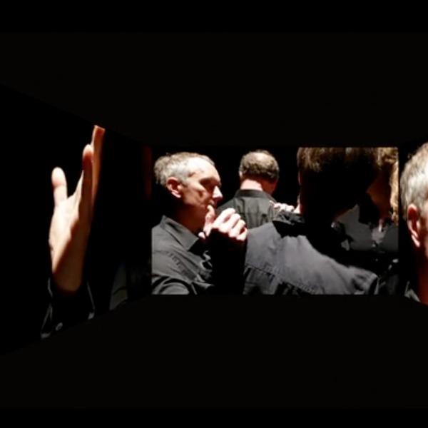 Singers of Neue Vocalsolisten on three screens in The Journey